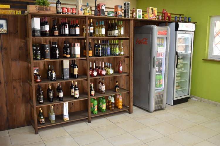exhibición de bebidas para la venta, vinos y licores en los estantes y bebidas carbonatadas en latas o botellas en refrigeradores