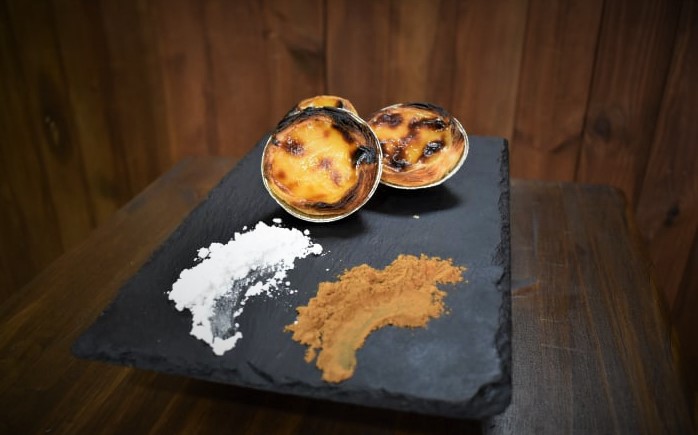 Visualización de pasteis de nata con azúcar glass y canela